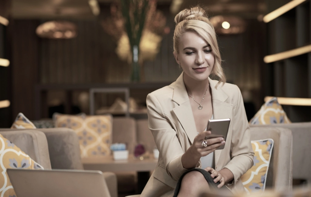 business woman in hotel checking text messages on her phone