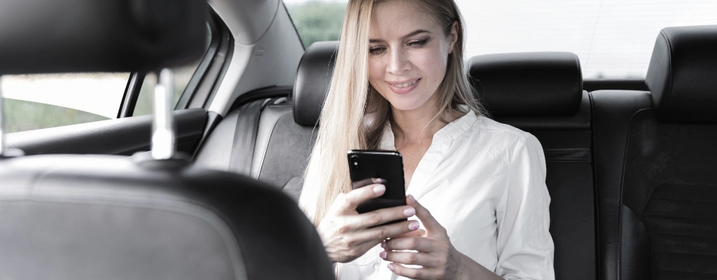 Business woman on phone during airport to airport transfer