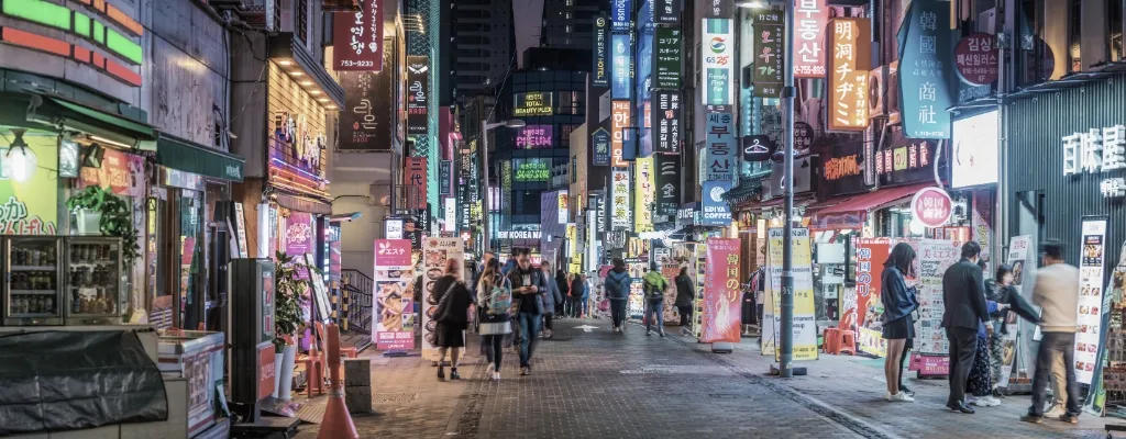 Busy street crowds shoppers neon nightlife panorama Myeong-dong Seoul Korea