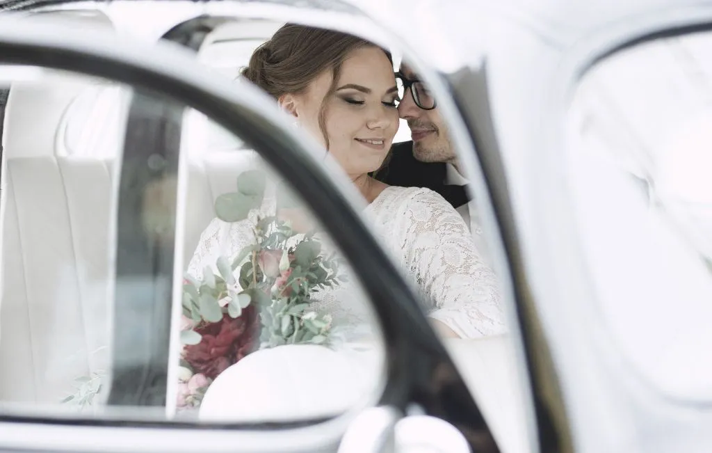 couple in a car during wedding day