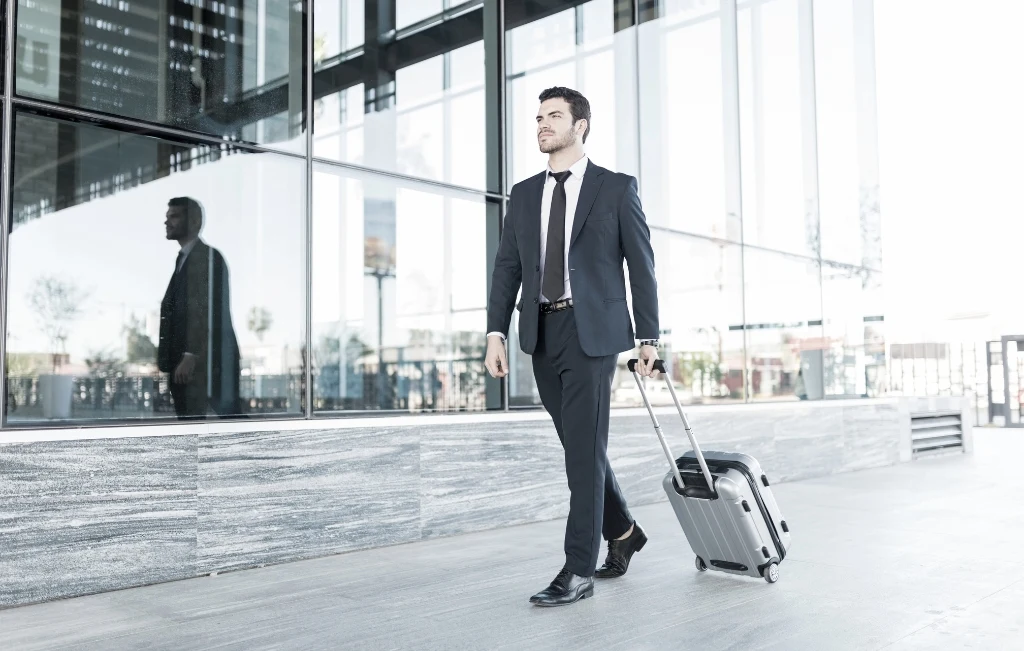 man in suit walking with luggage