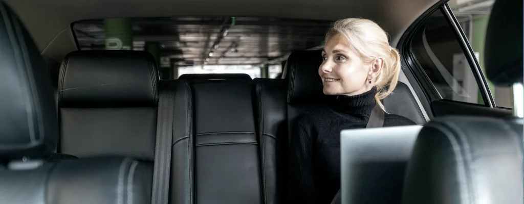 Business woman working inside the car during her airport service