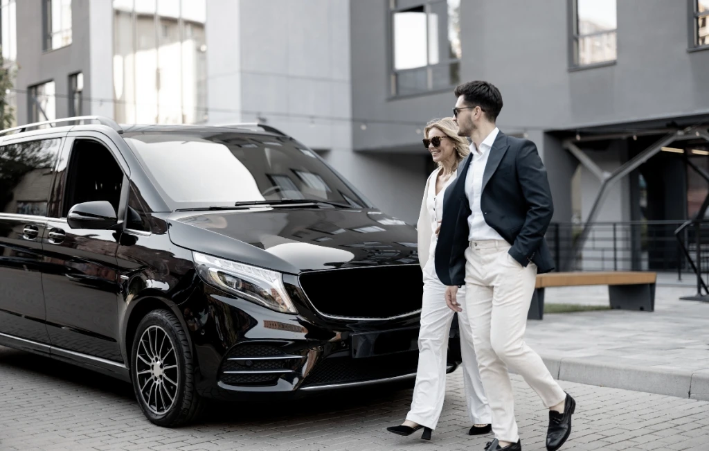 businessmen walks to minivan for airport car service