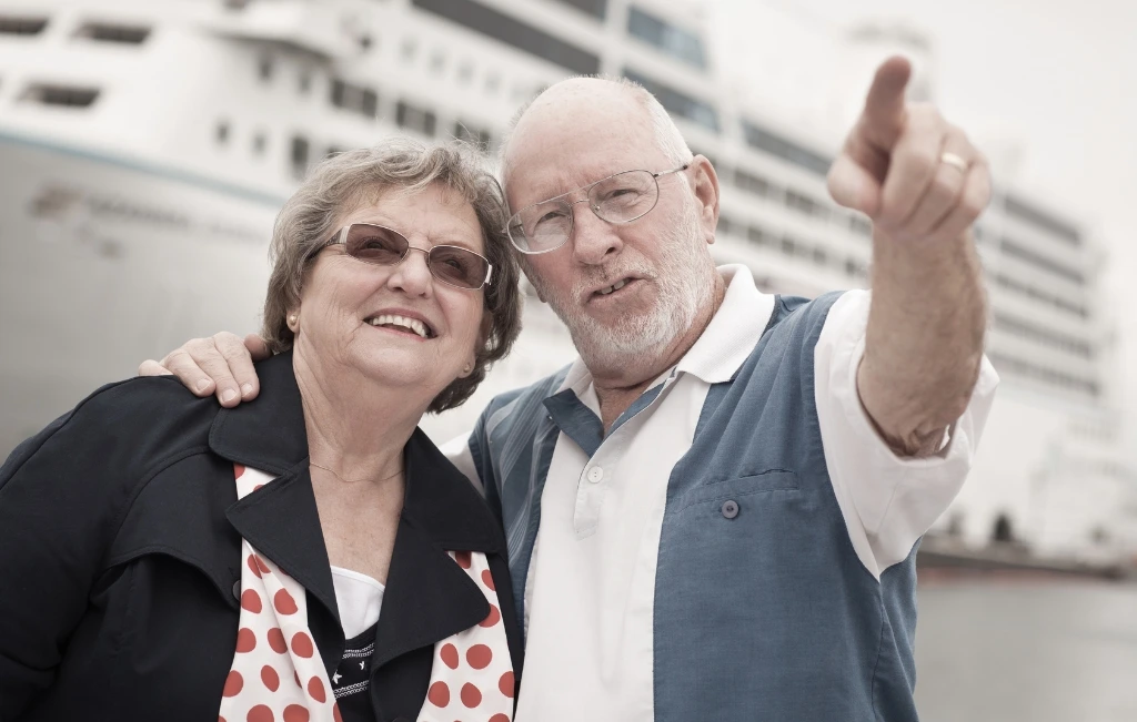 couple in shore in front of cruise ship