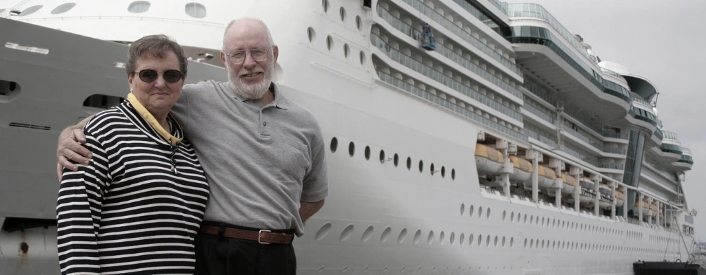 couple poses at cruise ship after airport transfer